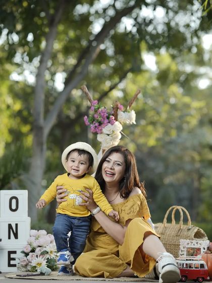 A mother and her one-year-old son enjoying a happy moment during an outdoor birthday photoshoot. These sessions capture the fun and energy of your growing child.