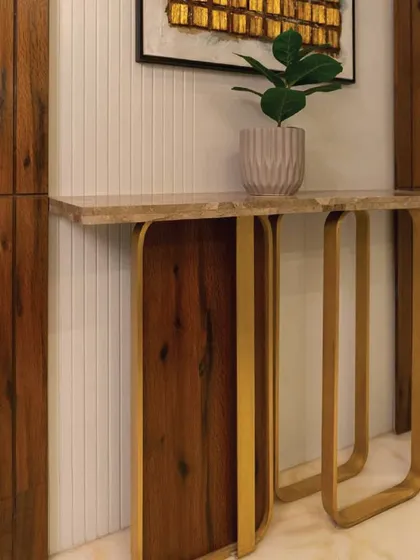 A detail shot of a bespoke console table from the project, showcasing the use of bent wood and brass to create a piece of functional art.