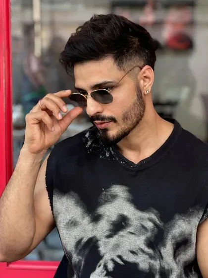Adjusting the shades, this client is ready to go with his fresh fade haircut and perfectly shaped beard.