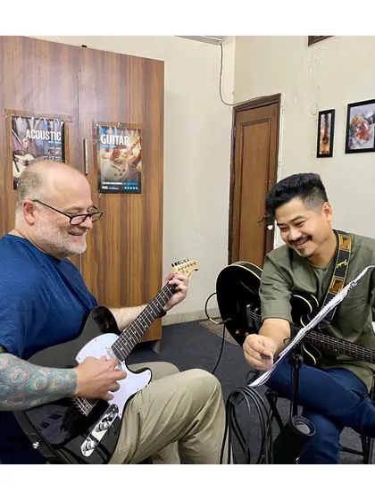 A happy moment during a guitar lesson. We believe learning should be a joyful experience, and our instructors teach with a happy heart.