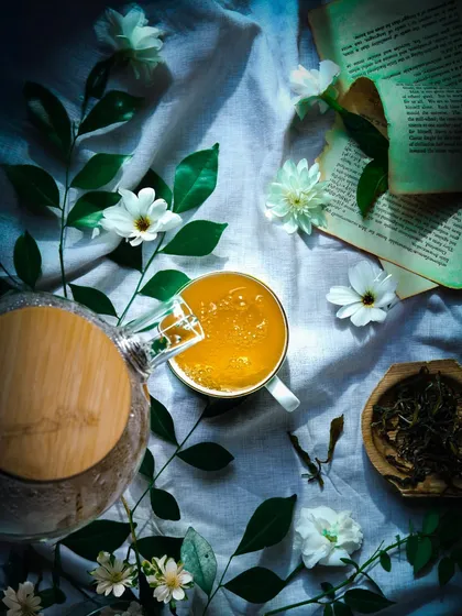A dark and moody tea flat lay, using shadows and a single light source to create a "moonlit garden" effect. This style is poetic and artistic.