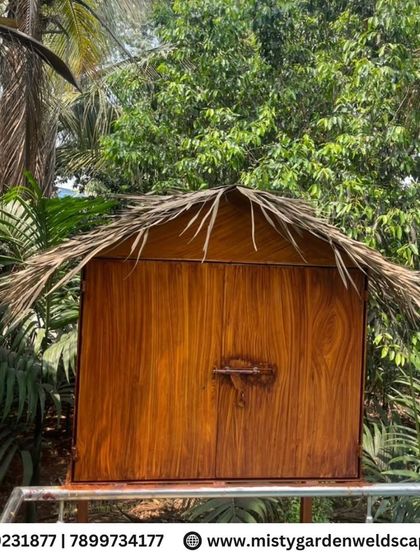 A custom-built wooden storage cabinet with a thatched roof, designed to complement the rustic aesthetic of the farmhouse and cow shed.