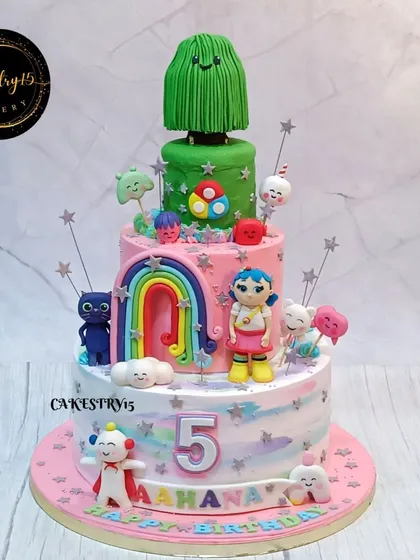 A grand three-tier "Rainbow Kingdom" cake for a fifth birthday. This black forest cake is a fantasy of colors, with a wishing tree topper and characters from a favorite cartoon.