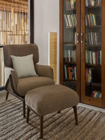 The private study in the House of Terraces offers a peaceful escape. A comfortable armchair and ottoman are paired with a floor-to-ceiling bookshelf, creating the perfect corner for reading and contemplation.