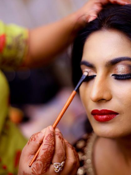 A make-up artist applies eyeshadow to the bride. We capture these behind-the-scenes moments to tell the complete story of your transformation.