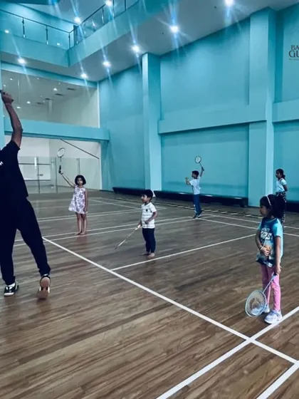 A coach demonstrates the overhead smash technique to a group of young learners at our Gera World of Joy summer camp.