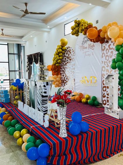 A side view of the large stage decoration for the jungle-themed first birthday, showing the depth and scale of the setup in a party hall.