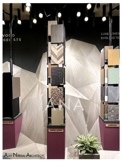 A detailed shot of the veneer samples on display at the Pllum Legno booth. The variety of textures and patterns, from wood grain to terrazzo, is highlighted by the focused lighting and clean presentation.