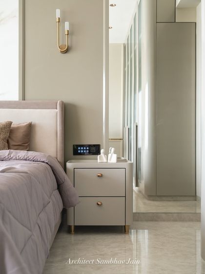 This bed wall is a study in soft sophistication and detailed craftsmanship. Upholstered in rich, textured fabric, the headboard extends across the wall in clean horizontal panels, offering both visual warmth and acoustic softness.