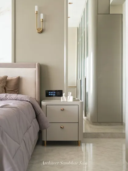 This bed wall is a study in soft sophistication and detailed craftsmanship. Upholstered in rich, textured fabric, the headboard extends across the wall in clean horizontal panels, offering both visual warmth and acoustic softness.