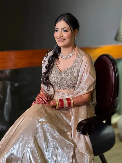 A happy, smiling bride ready for her reception. The soft glam makeup and elegant braided ponytail create a look that is both modern and timeless.