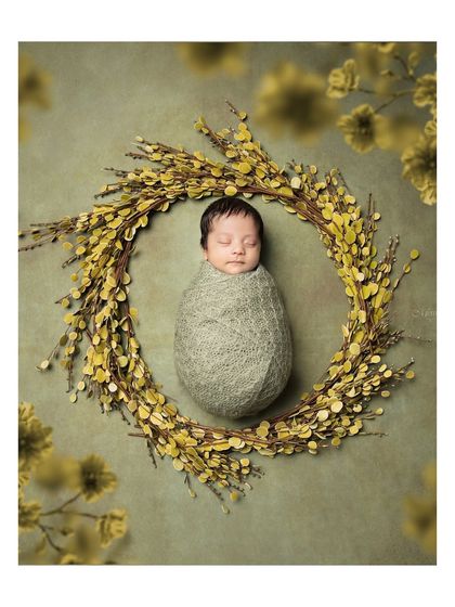 A peacefully sleeping newborn, swaddled snugly in a wreath of yellow flowers. This artistic composition highlights the delicate nature of your baby.