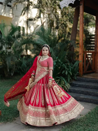 Every bride deserves a portrait that captures her grace and joy. We create these beautiful, classic shots, like this one of the bride twirling in her stunning red lehenga, to give you a memory you will cherish forever.