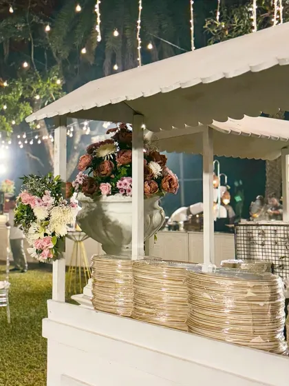 My catering cart, adorned with flowers and stacked with eco friendly plates, is ready for service. This setup shows my commitment to both aesthetics and sustainability.