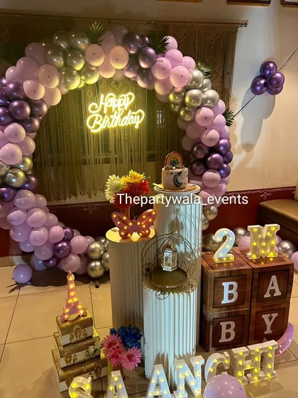 A beautiful ring decoration for a 2-month celebration. The purple and silver balloons with "BABY" blocks create a sweet and memorable setup.