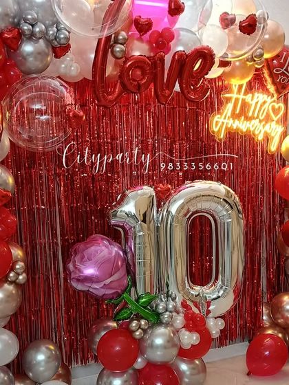 Another view of the 10th anniversary setup, showing the full balloon arch and the large silver '10' number balloons.