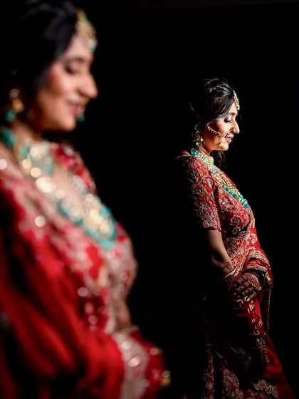 A creative bridal portrait showing a reflection of the bride. The play with focus and light creates an artistic and introspective mood, highlighting her serene beauty.