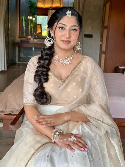 An elegant and ethereal look. This client is wearing a custom half-saree with a white skirt and a beige embroidered blouse, paired with a sheer dupatta.
