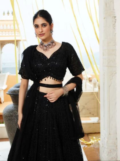 A client posing in the black sequined lehenga, showing its elegant silhouette.