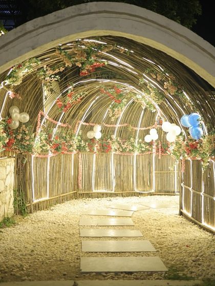 Our bamboo tunnel entrance decorated with balloons and flowers for a celebration. I can customize this space to match the theme of your event.