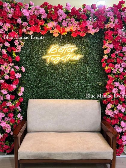 A straight-on view of the 'Better Together' anniversary backdrop, showing the full floral frame and the comfortable seating.