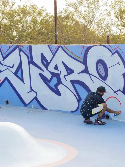 Filling in a classic 'ZERO' wildstyle piece on one of the park's main ramps. This shows the process of layering colors to create depth.