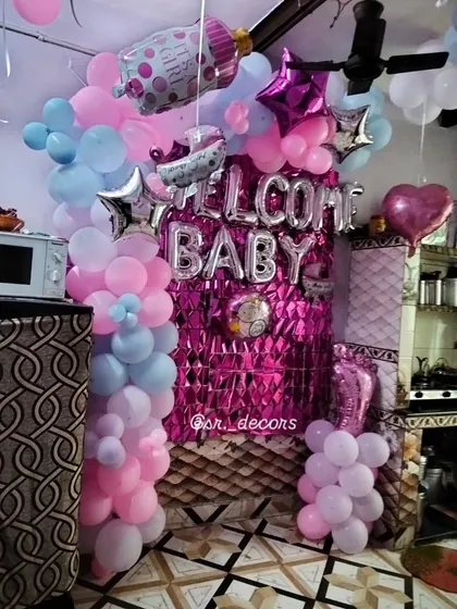 I can turn any corner of your home into a celebration spot. This welcome baby decoration features 'WELCOME BABY' foil balloons against a shiny pink curtain, framed by balloon pillars in classic pink and blue. It's a budget-friendly way to get a fantastic look.