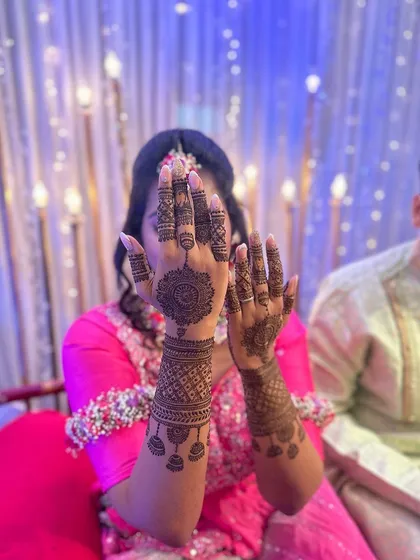 This design focuses on a central mandala on one hand and a cuff with hanging elements on the other, creating a stylish, asymmetrical look for a party.