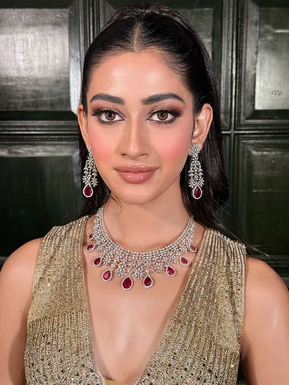 A classic portrait showcasing the harmony between the makeup and jewellery. The warm tones in the eyeshadow pick up the gold of the outfit, while the ruby drops add a pop of colour.