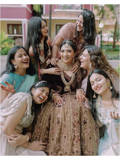 A bride surrounded by her laughing bridesmaids. This photo is full of genuine happiness and the joy of friendship on the wedding day.
