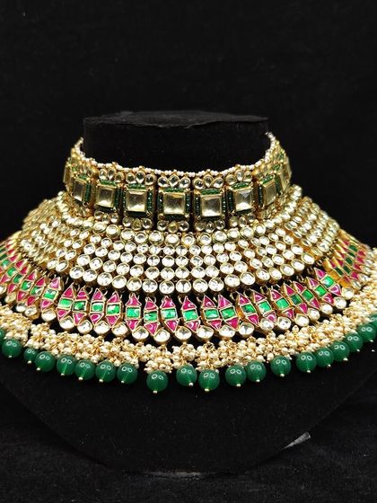 A beautiful choker combining green beads with pink and green enamel work. This is a vibrant and traditional piece from our rental collection.