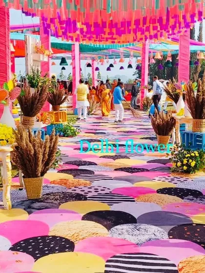 The walkway for the Haldi carnival, featuring a playful, multi-colored floor print, pink drapes, and deer props.
