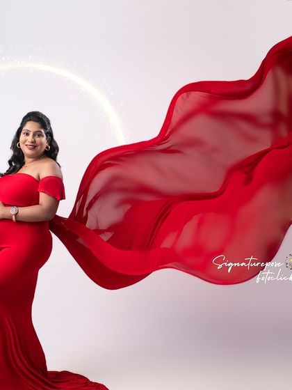 This artistic shot uses a flowing red fabric and a halo of light to create a divine and modern portrait.
