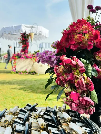 A tray of binoculars offered to guests at the polo luncheon, a practical and thematic detail that enhances the experience. In the background, you can see the beautiful floral decor.