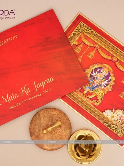 A close-up of our Mata Ka Jagran invitation, showcasing the rich red folder and the intricate 3D goddess motif card inside. The gold foil lettering adds a touch of divine elegance to this spiritual event invitation.