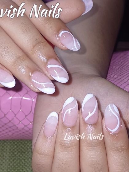 An abstract design with clean, white swirls over a sheer pink base on oval-shaped nails.