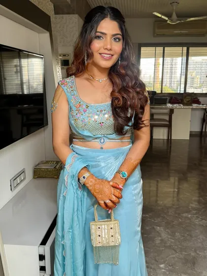 The half-up hairstyle keeps the hair managed while allowing the length and curls to be showcased. It is a practical yet beautiful choice for any wedding function.