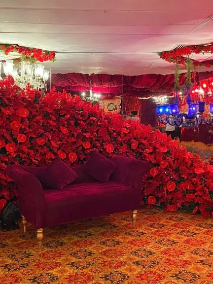 A truly dramatic photo booth. I used a mountain of red flowers to surround this velvet couch, creating an immersive and unforgettable photo opportunity.
