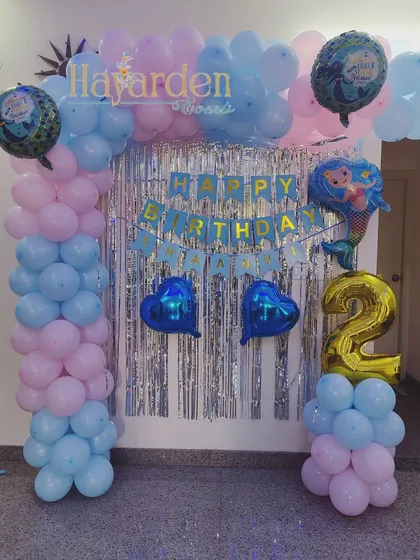 A basic but fun home decoration for a 2nd birthday. This setup includes a simple balloon frame, a fringe backdrop, and themed foil balloons.