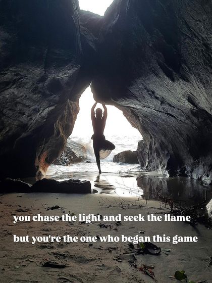 Vrikshasana (Tree Pose) in a cave by the sea. We often chase an external light or flame, but the practice of yoga reminds us that the source of the light we seek is already within us.