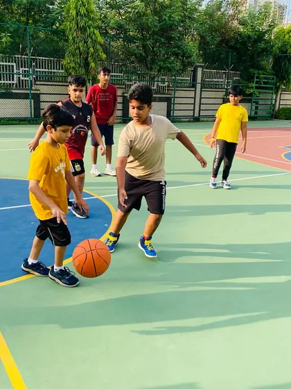 A young player learns to dribble with both hands, a fundamental skill for all positions.