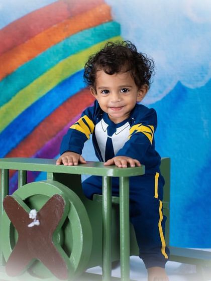 A happy smile from our little pilot as he flies through a rainbow sky.