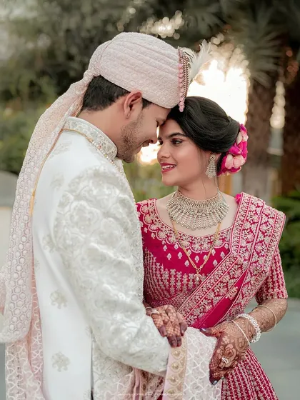 A close-up that focuses on the pure, heartfelt connection between the couple. Their foreheads touching, eyes closed in a moment of serene happiness, this image captures the intimacy and trust that forms the foundation of their bond, framed by their exquisite wedding attire.