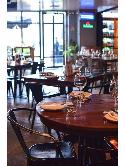 A classic restaurant interior at The Wine Company. This image focuses on the table setting, ready for guests, to convey a sense of anticipation and quality service for a fine-dining establishment.