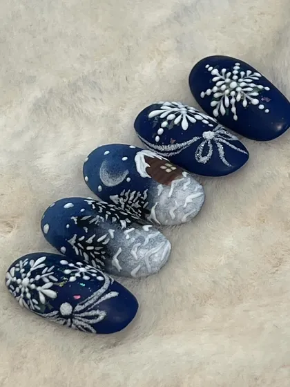 Another angle of the snowy Christmas nail art, showing the continuity of the winter scene across the nails.