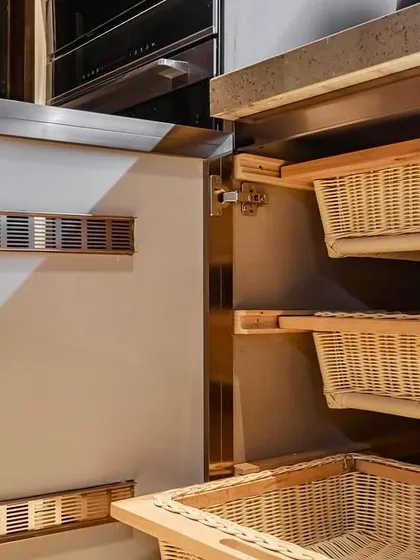Wicker baskets integrated into the cabinetry provide a rustic yet functional touch, perfect for storing root vegetables.