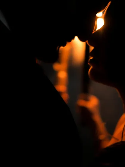 A silhouette of a near-kiss, outlined by warm, glowing light. The focus is on the anticipation and the space between them, making it a powerful and romantic image.
