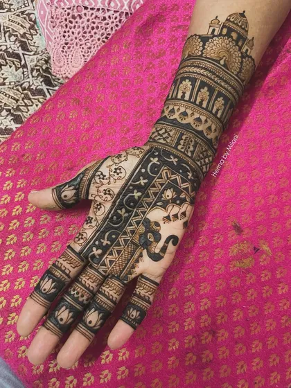 A bold and beautiful bridal mehendi design. The dark, filled-in patterns create a striking contrast, featuring elephants and architectural motifs.