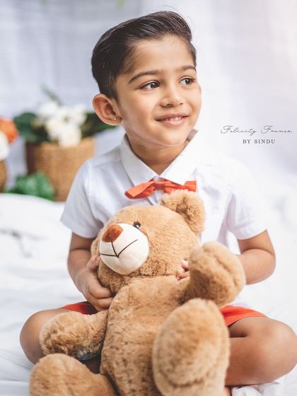 A classic portrait of a four-year-old boy with his teddy bear. Outdoor settings provide beautiful natural light for milestone photos.