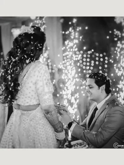 The ring exchange captured in a dynamic black and white photo, with the sparkle of fireworks adding a magical texture to the background.